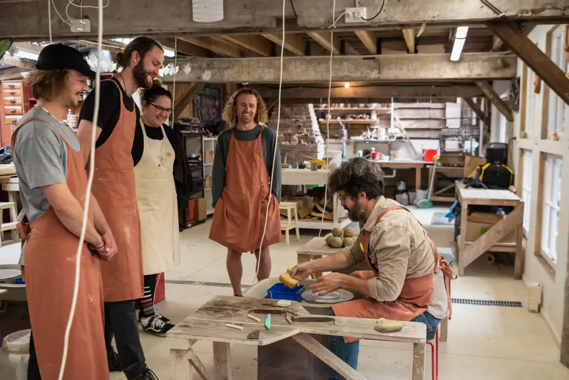 Pottery tutor giving a demonstration to pottery class