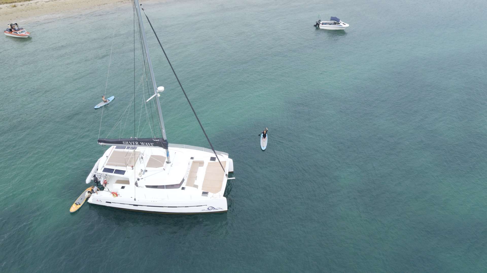 Silverwave at anchor at Roberton Island with paddleboards headed ashore
